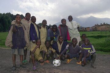 Group photo at the football field, Nyiragongo volcano looms in the background. (Photo: Tom Pfeiffer)