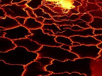 Geometric pattern of the thin black crust on the lava lake´s surface that is continuously broken apart by heat and degassing from the underlying liquid lava. (Photo: Ingrid Smet)