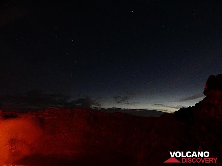 The lava lake´s red glow illuminates the steep  inner walls of Nyiragongo´s summit caldera whilst the sky to the east shows both the nightly stars and first morning light. (Photo: Ingrid Smet)