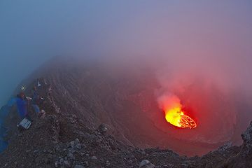 Unsere Gruppe in Position am Kraterrand oberhalb des Campingplatzes in der Abenddämmerung – das Lieblingslicht der Fotografen, wenn sich Lavaglühen mit der Dämmerung vermischt. (Photo: Tom Pfeiffer)