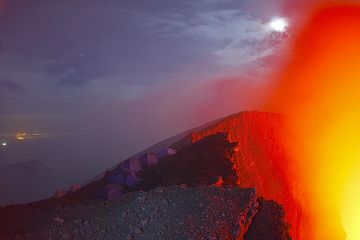 Die Lichter der Stadt Goma im Hintergrund erinnern mich daran, wie ich auf dem Vulkan Ätna stand und auf Catania hinunterblickte ... (Photo: Tom Pfeiffer)