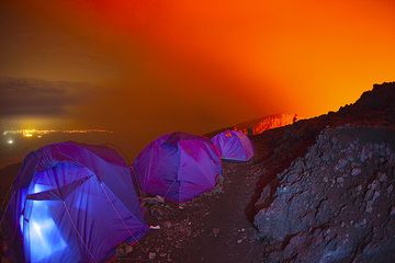 Time to wake up and enjoy the last hour of darkness before sunrise! As usual, Gilles is already up before all others and standing at the crater rim behind, to watch the lava lake. (Photo: Tom Pfeiffer)