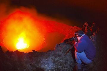 Photographer Franz studies the light of the lava lake.  (Photo: Tom Pfeiffer)