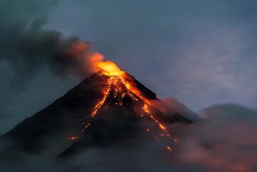 Cependant, à la tombée de la nuit, les explosions cessent plus ou moins et les nuages jouent avec le volcan. (Photo: Tom Pfeiffer)