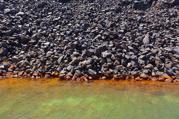 Bloquer une coulée de lave dans une baie de l'île de Nea Kameni (Santorin), où des sources hydrothermales sous-marines déposent de la boue de fer verdâtre, qui s'oxyde en orange près de la surface. Un spa naturel génial et complètement bizarre ! (Photo: Tom Pfeiffer)