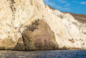 Submarine white tuffs covering a darker intrusion (cryptodome), sea cliff between White and Red beach (Photo: Tom Pfeiffer)