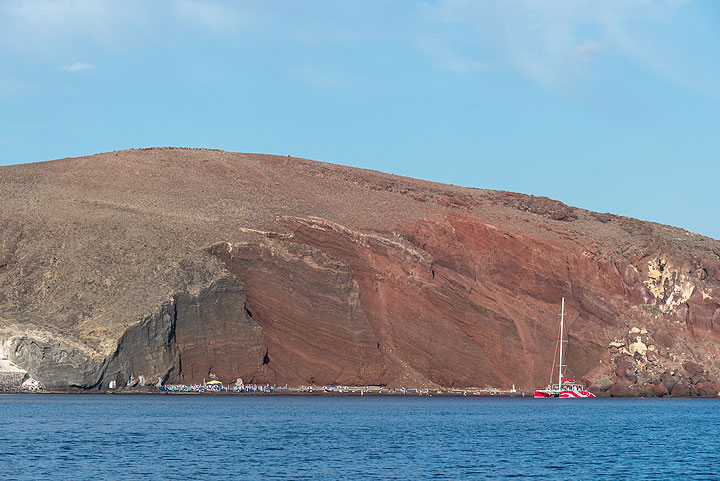 Roter Strand von Santorini – ein alter Schlackenkegel, der durch Erosion in zwei Hälften geschnitten wurde – vom Meer aus gesehen (Photo: Tom Pfeiffer)