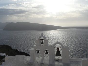 Oia bells tall on a winter afternoon - Therasia island in the background. (Photo: Ingrid Smet)