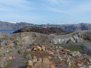 Vue depuis le cratère central de Nea Kameni jusqu'à un dôme et une coulée de lave périphériques et au-delà des falaises de la caldeira sous la ville de Fira sur l'île de Théra. (Photo: Ingrid Smet)