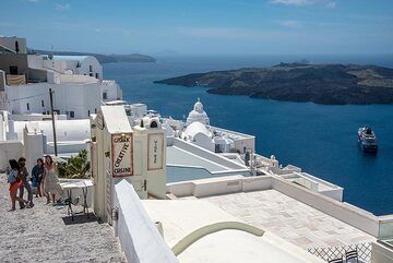 Die Terrasse unter der Kathedrale von Fira ist ein beliebter Treffpunkt mit herrlichem Blick über die Altstadt, die von der Agios-Minas-Kapelle und der Caldera dominiert wird. (Photo: Tom Pfeiffer)