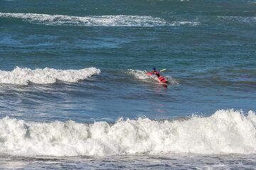 The waves on the south shore are perfect for sea kayak surfing, as a skillful rider demonstrates in the morning. (Photo: Tom Pfeiffer)