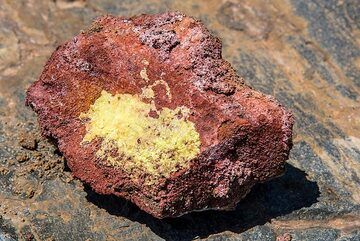 Échantillon d'une roche recouverte d'oxydes et de cristaux de soufre pur provenant d'une fumerolle active. (Photo: Tom Pfeiffer)