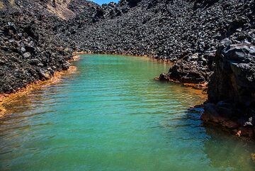 La baie thermale secrète de Nea Kameni. Les sources sous-marines déposent du fer dans l’eau, vert au fond et oxydé en orange à la ligne de flottaison. (Photo: Tom Pfeiffer)