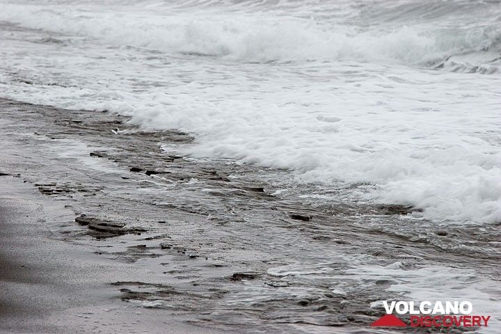 Spray of waves on the beach, exposing its beach rock (Photo: Tom Pfeiffer)
