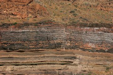 A characteristic 4 m thick dark banded layer is in the caldera cliff of Santorini near Fira. It is a spectacular welded pumice fall deposit, corresponding to the Plinian phase of so-called Middle Pumice eruption (ca. 60 Ka). (Photo: Tom Pfeiffer)