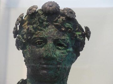 A very lifelike bronze bust statue of a young man seems to be staring right back at you with a faint smile. (Photo: Ingrid Smet)