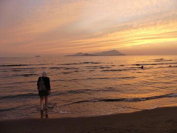 The sand beach at Miseno in the golden light of sunset, looking towards the volcanic islands of Procida (centre foreground) and Ischia (double hill silhouette in centre background). (Photo: Ingrid Smet)