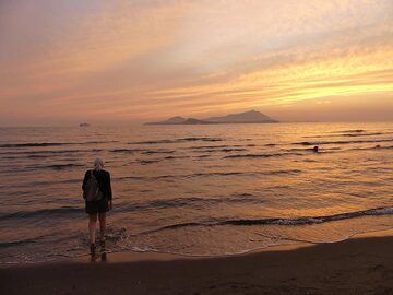 La plage de sable de Miseno dans la lumière dorée du coucher du soleil, regardant vers les îles volcaniques de Procida (au centre au premier plan) et d'Ischia (silhouette à double colline en arrière-plan au centre). (Photo: Ingrid Smet)