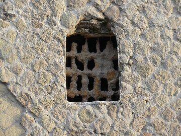 Whilst the wall of this building was constructed  with the yellow tuff that erupted from the Phlegraean fields some 15,000 years ago, the metal window grid got covered by ash and lapilli from the 79 AD eruption of Mt Vesuvius. (Photo: Ingrid Smet)