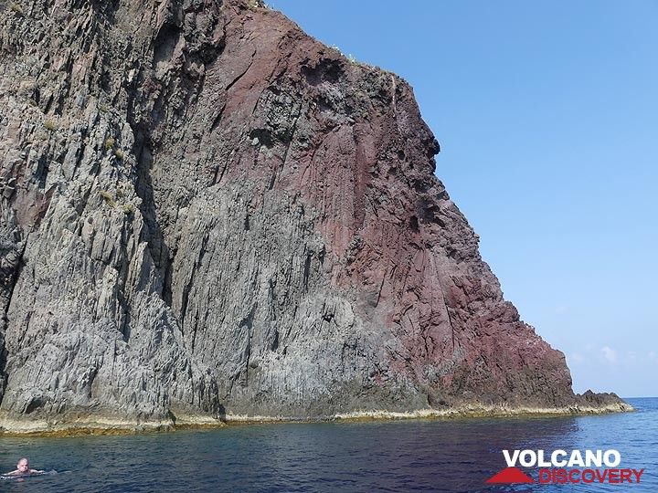 The outer zone of the volcanic neck of Strombolicchio is red-oxidised whilst the inner grey part clearly shows subvertical cooling joints. (Photo: Ingrid Smet)