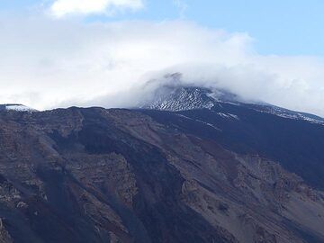 Avant de retourner à notre hôtel, les nuages qui couvraient auparavant la zone du sommet de l'Etna se dissipent partiellement et dévoilent l'objectif enneigé de notre randonnée du lendemain. (Photo: Ingrid Smet)