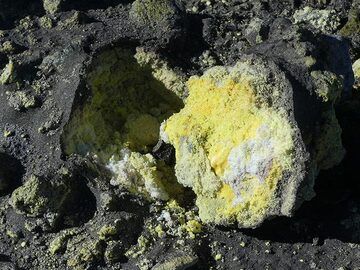 The E-NE rim of the Voragine - Bocca Nuova crater complex is the scene for intense fumarolic activity which has created a thick blanket of sulfur covered only by a thin later of ash. (Photo: Ingrid Smet)