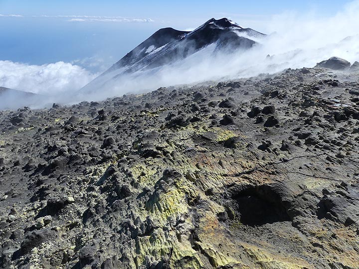 View from the thick sulfur layer with thin ash cover on the east rim of the Voragine crater (foreground) towards the SE crater complex (background). (Photo: Ingrid Smet)
