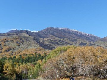 Vue depuis le Rifugio Citelli vers les flancs inférieurs est de l'Etna aux couleurs automnales et le complexe de cratères SE (à gauche) et NE (à droite). (Photo: Ingrid Smet)