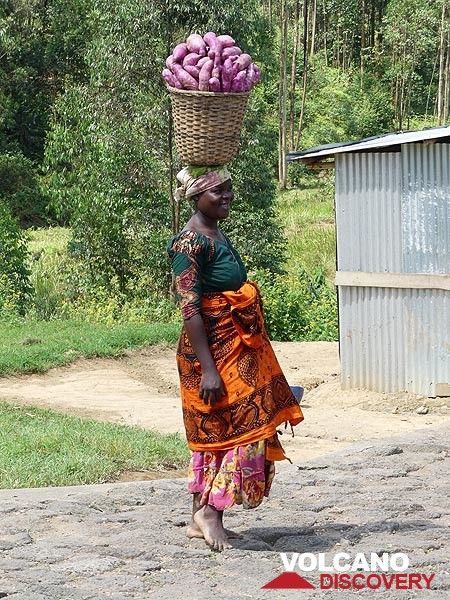 Tag 2 – Eine ruandische Frau bringt ihre Ernte auf traditionelle Weise zum lokalen Markt (Photo: Ingrid Smet)