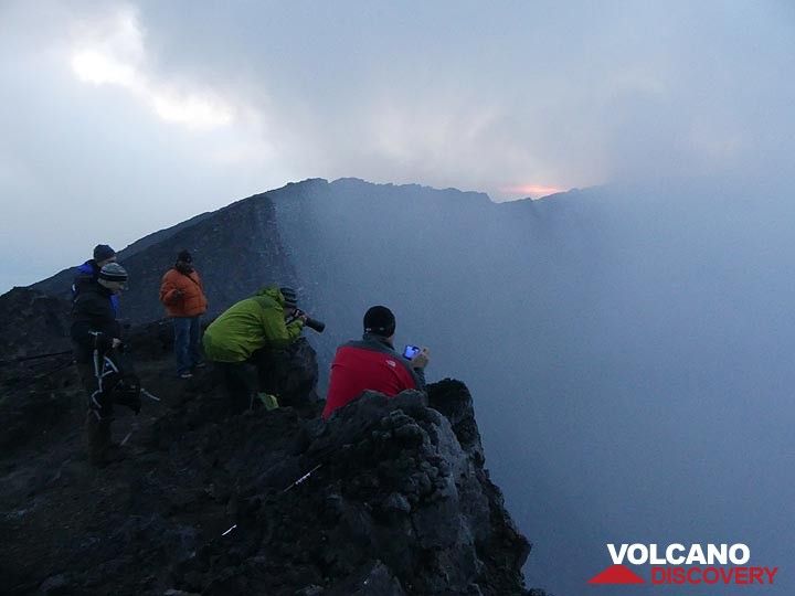 Jour 3 - Assis sur le bord du cratère en attendant que les nuages et les gaz volcaniques se soulèvent pour une première vue sur la caldeira (Photo: Ingrid Smet)