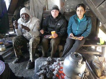 Tag 4 – Gruppenfrühstück in unserem „Esszimmer“ unter den älteren Holzhütten, die zuvor zum Zelten errichtet wurden (Photo: Ingrid Smet)