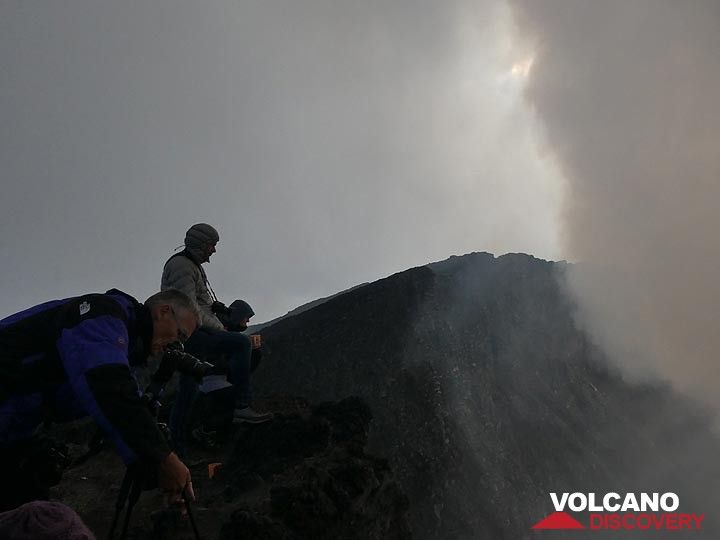 Jour 4 - Préparation des trépieds pour l'observation du soir en espérant que les nuages et les gaz volcaniques (à droite) disparaissent bientôt (Photo: Ingrid Smet)