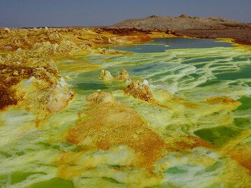 The high activity at Dallol´s hydrothermal system creates numerous greenish (to blue) acid ponds which cascade one into the other, making colourful terraces between the white-yellow-ornage-brown salt deposits. (Photo: Hans and Jooske)