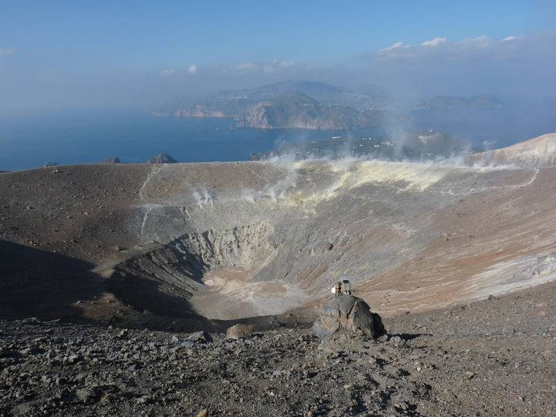 Crater of Vulcano volcano, Lipari in the background and larhe bread crust bomb in the foreground. Italy's Volcanoes: The Grand Tour, October 2013 (Photo: Ingrid)