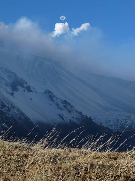 Der neue südöstliche Krater könnte hinter den Wolken verborgen sein, aber der Rauchring und die hoch darüber aufsteigenden Wolken verraten, dass er aktiv ist ... Ätna, 11. November 2013 (Photo: Ingrid)