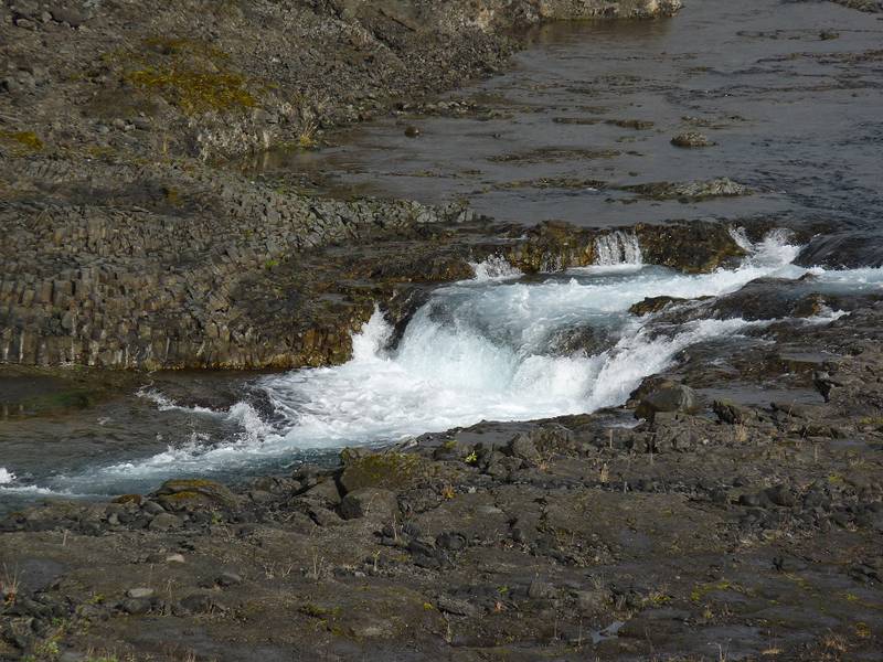 Während sich der Fluss einen Weg durch das Lavafeld bahnt, bilden sich kleine Wasserfälle und legen Säulenverbindungen in seinem Flussbett frei. In der Nähe von Hrauneyjalón, südliche Grenze des isländischen Hochlandes – 12. September 2014. (Photo: Ingrid)