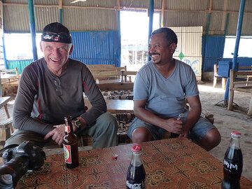 TAG 4: Von Afrera nach Dodom (Basislager Erta Ale) – Genießen Sie ein letztes kühles Getränk, während der Cheffahrer einen Afar-Straßenführer und Polizisten für die Fortsetzung unserer Expedition organisiert (Photo: Ingrid)