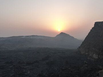 DAYS 5-6-7: Erta Ale - We reach the rim of Erta Ale´s large collapse caldera by sun rise, having a first look across the caldera floor towards the vent with the active lava lake... (Photo: Ingrid)