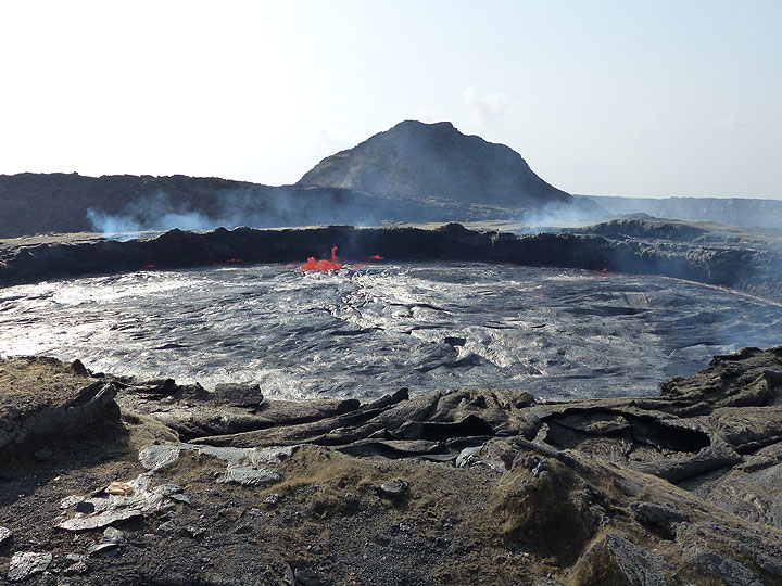 DAYS 5-6-7: Erta Ale - First view onto the lava lake - its level is surprisingly high, in fact the highest since its overflow in December 2010. Note the thick deposits of goldenbrown Pele´s hair on the foreground, which... (Photo: Ingrid)