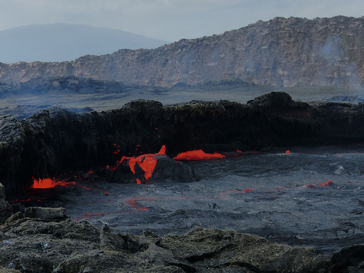 DAYS 5-6-7: Erta Ale - Activity at the edge of the lava lake is the expression of the lake´s internal heat convection and degassing. Note the blue-ish gas (sulphur dioxide, SO2)) emanated from around the active vent. (Photo: Ingrid)