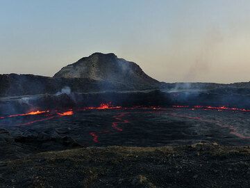 DAYS 5-6-7: Erta Ale - The active lava lake at dusk with the look-out hill in the background. (Photo: Ingrid)