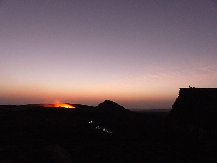 DAYS 5-6-7: Erta Ale - Several groups come and go throughout the day and night to observe the lava lake. Particularly around sun set or - in this case - sun rise one can observe small silhouettes near the active crater and on top of the caldera rim. (Photo: Ingrid)
