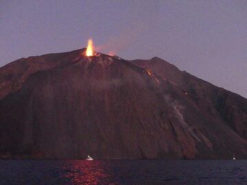 Une forte éruption semblable à une bougie provenant des deux évents dans la zone orientale de la terrasse du cratère se reflète en rouge profond sur la surface de la mer sous la Sciara. (Photo: Ingrid)