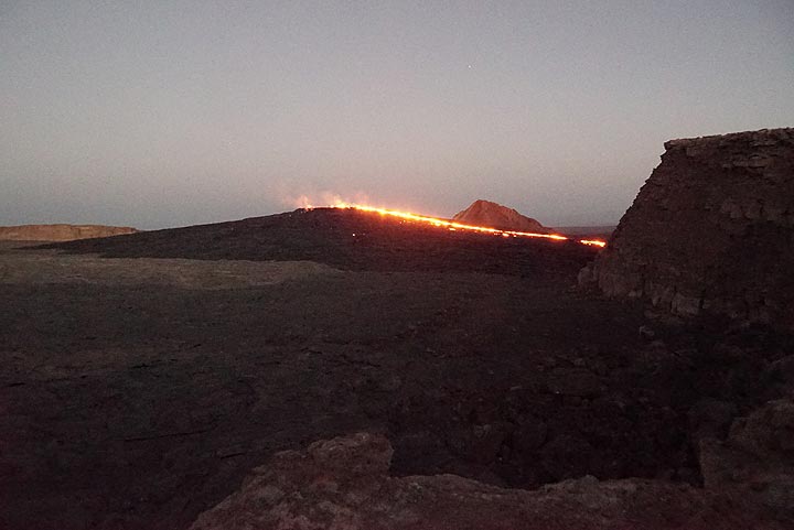 16 Jan evening: View from NW towards the south crater with its lava lake from campsite. What used to be a pit crater has been replaced by a sizeable lava shield currently feeding an overflow to the western caldera wall. (Photo: Paul Reichert)