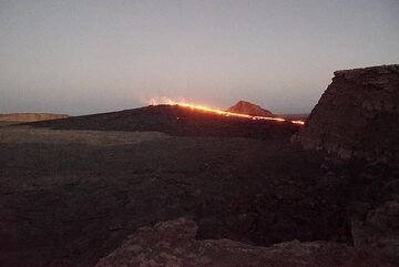 16 Jan evening: View from NW towards the south crater with its lava lake from campsite. What used to be a pit crater has been replaced by a sizeable lava shield currently feeding an overflow to the western caldera wall. (Photo: Paul Reichert)