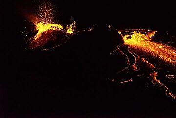 The lava flow through the breached rim of the perched lava lake continues all night of 19-20 Jan. (Photo: Paul Reichert)