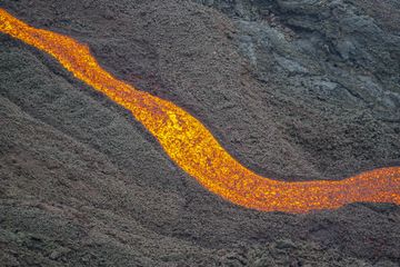 Nahaufnahme eines schmalen Kanals mit schnell fließender Lava (Photo: Ronny Quireyns)