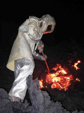 Anthony sammelt im Hitzeschutzanzug eine Lavaprobe vom Ausbruch des Piton de la Fournaise im Jahr 2006 (Photo: SBCabusson)