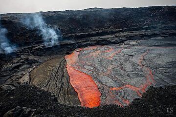 La croûte noire récemment refroidie est envahie et consommée par de la lave liquide chauffée au rouge qui elle-même refroidit rapidement et forme une croûte (site d'éruption de la fissure d'Erta Ale) (c)