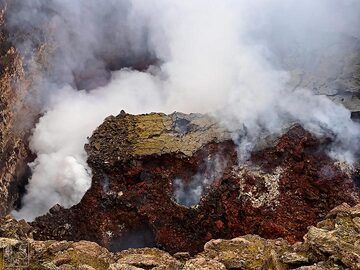 Daytine-Blick hinunter in den Südkrater, mit großen Teilen der inneren Kraterwände, die eingestürzt sind (Mitte) und dicken Wolken vulkanischer Gase, die den Blick auf den aktiven Lavasee darunter verdecken (oben in der Mitte und links) (Erta Ale-Gipfelcaldera) (c)